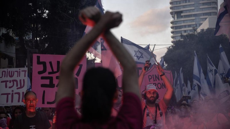 Demonstran mengibarkan bendera selama protes terhadap RUU perbaikan peradilan pemerintah Israel di Tel Aviv pada 20 Mei 2023. (AHMAD GHARABLI/AFP via Getty Images)