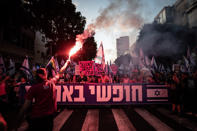 Demonstran mengibarkan bendera selama protes terhadap RUU perbaikan peradilan pemerintah Israel di Tel Aviv pada 20 Mei 2023. Demonstran mengibarkan bendera selama protes terhadap RUU perbaikan peradilan pemerintah Israel di Tel Aviv pada 20 Mei 2023. (AHMAD GHARABLI/AFP via Getty Images)