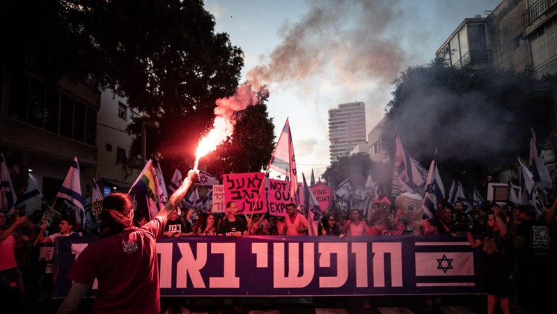 Demonstran mengibarkan bendera selama protes terhadap RUU perbaikan peradilan pemerintah Israel di Tel Aviv pada 20 Mei 2023. (AHMAD GHARABLI/AFP via Getty Images)