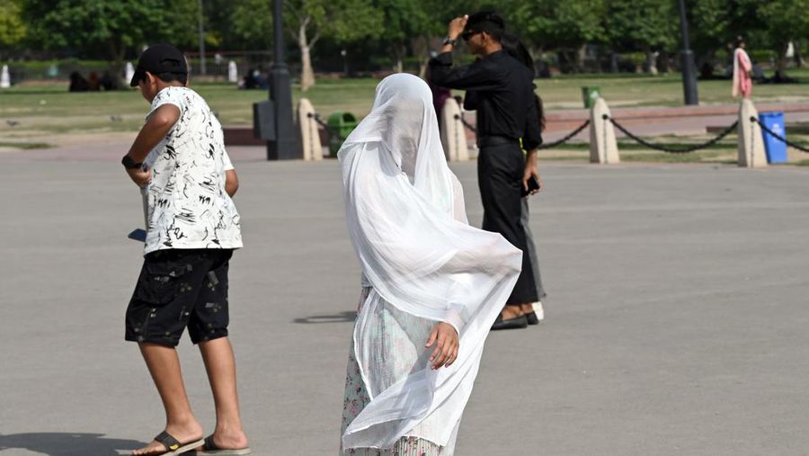 Orang-orang keluar di Gerbang India pada sore yang panas, pada 21 Mei 2023 di New Delhi, India. (Sanjeev Verma/Hindustan Times via Getty Images)