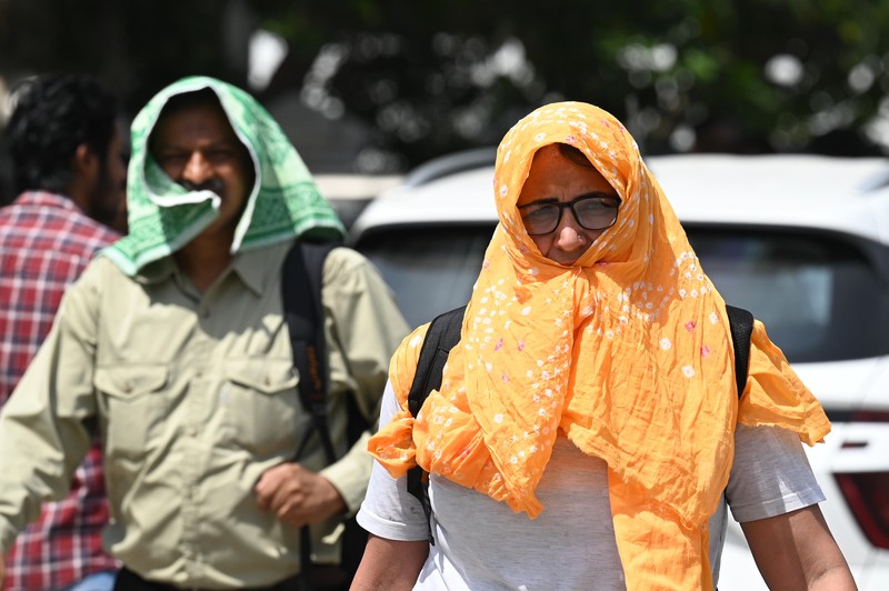 Orang-orang keluar di Gerbang India pada sore yang panas, pada 21 Mei 2023 di New Delhi, India. (Sanjeev Verma/Hindustan Times via Getty Images)