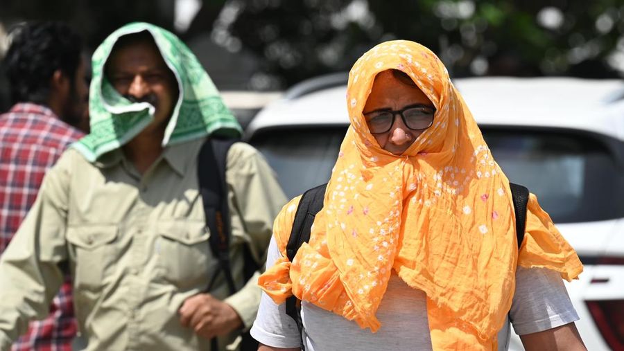 Orang-orang keluar di Gerbang India pada sore yang panas, pada 21 Mei 2023 di New Delhi, India. (Sanjeev Verma/Hindustan Times via Getty Images)