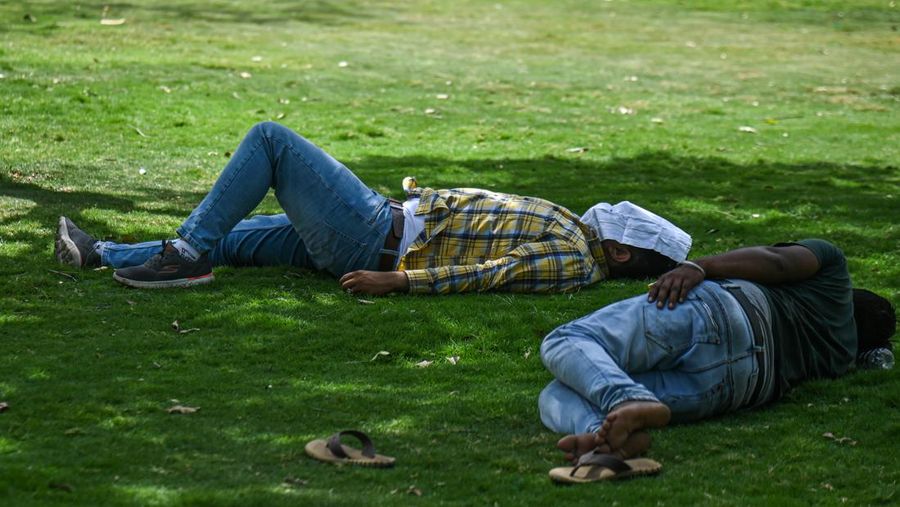 Orang-orang keluar di Gerbang India pada sore yang panas, pada 21 Mei 2023 di New Delhi, India. (Sanjeev Verma/Hindustan Times via Getty Images)