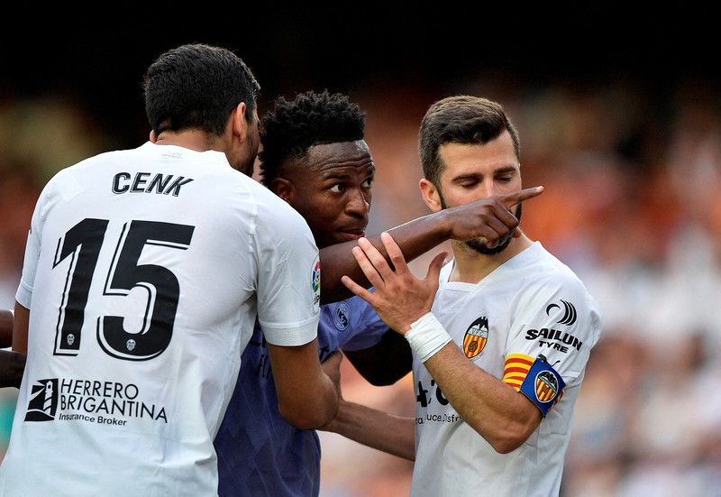 FILE PHOTO: Soccer Football - LaLiga - Valencia v Real Madrid - Mestalla, Valencia, Spain - May 21, 2023 Real Madrid's Vinicius Junior gestures towards a fan as Valencia's Jose Gaya and Cenk Ozkacar attempt to restrain him REUTERS/Pablo Morano/File Photo