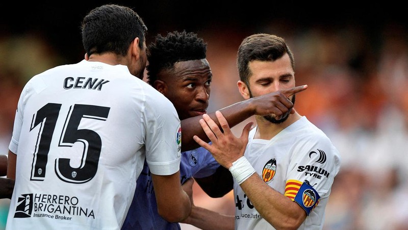 FILE PHOTO: Soccer Football - LaLiga - Valencia v Real Madrid - Mestalla, Valencia, Spain - May 21, 2023 Real Madrid's Vinicius Junior gestures towards a fan as Valencia's Jose Gaya and Cenk Ozkacar attempt to restrain him REUTERS/Pablo Morano/File Photo