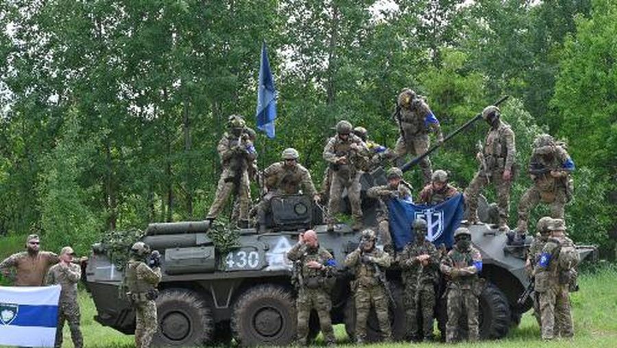 Fighters of the Russian Volunteer Corps and allied group, the Freedom of Russia Legion, stand next to a seized armoured personnel carrier during a presentation for the media in northern Ukraine, not far from the Russian border, on May 24, 2023, amid Russian military invasion on Ukraine. Russian nationals fighting on Ukraine's side on May 24 hailed as a