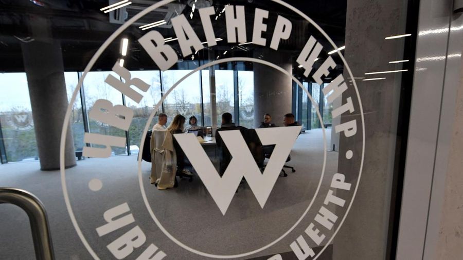 People sit at the desk in the office in the 'PMC Wagner Centre', associated with the founder of the Wagner private military group (PMC) Yevgeny Prigozhin, during the official opening of the office block on the National Unity Day, in Saint Petersburg, on November 4, 2022. (Photo by Olga MALTSEVA / AFP) (Photo by OLGA MALTSEVA/AFP via Getty Images)