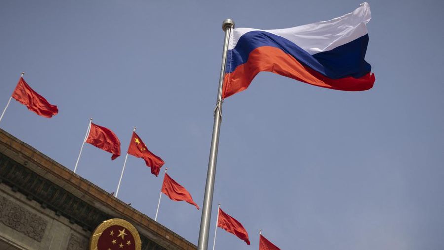 Bendera nasional Rusia berkibar di depan Aula Besar Rakyat sebelum upacara penyambutan Perdana Menteri Rusia Mikhail Mishustin di Beijing pada 24 Mei 2023. (THOMAS PETER/POOL/AFP via Getty Images)