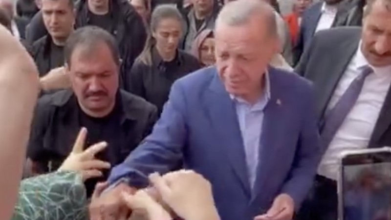 Presiden Turki Tayyip Erdogan membagikan uang kepada para pendukung yang berkumpul di luar TPS. (REUTERS)