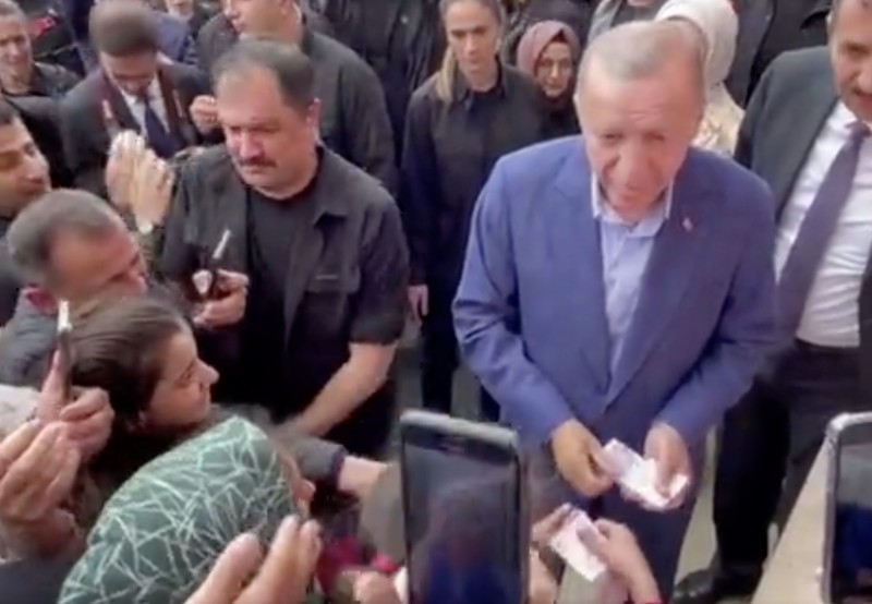 Presiden Turki Tayyip Erdogan membagikan uang kepada para pendukung yang berkumpul di luar TPS. Presiden Turki Tayyip Erdogan membagikan uang kepada para pendukung yang berkumpul di luar TPS. (REUTERS)