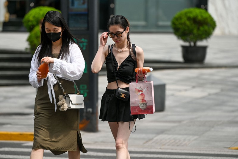 Warga beraktivitas saatb gelombang panas di Kota Shanghai, China, Senin (29/5/2023). (AFP via Getty Images)