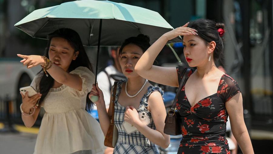 Warga beraktivitas saatb gelombang panas di Kota Shanghai, China, Senin (29/5/2023). (AFP via Getty Images)