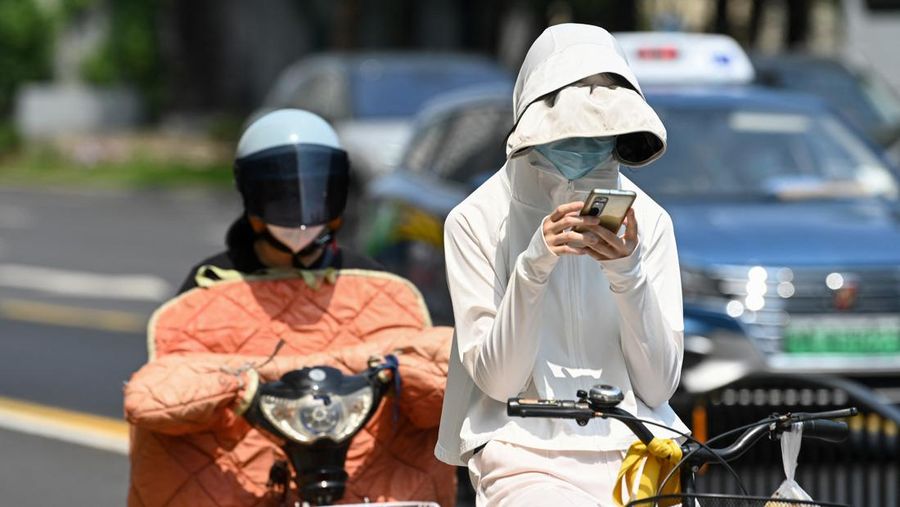 Warga beraktivitas saatb gelombang panas di Kota Shanghai, China, Senin (29/5/2023). (AFP via Getty Images)