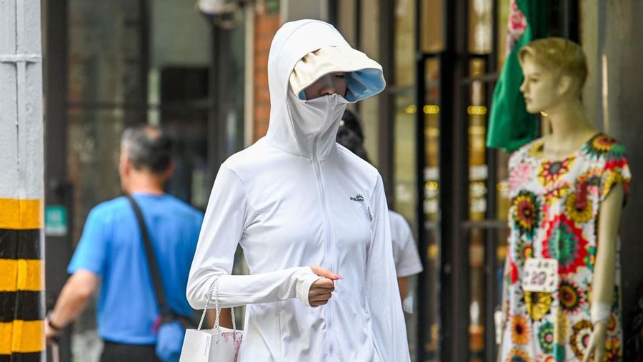 Warga beraktivitas saatb gelombang panas di Kota Shanghai, China, Senin (29/5/2023). (AFP via Getty Images)