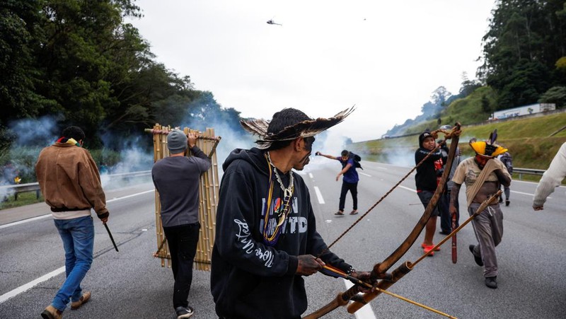 Guarani Indigenous block the Bandeirantes highway with burning tires to protest proposed legislation that would change the policy that demarcates Indigenous lands on the outskirts of Sao Paulo, Brazil, Tuesday, May 30, 2023. (AP Photo/Ettore Chiereguini)