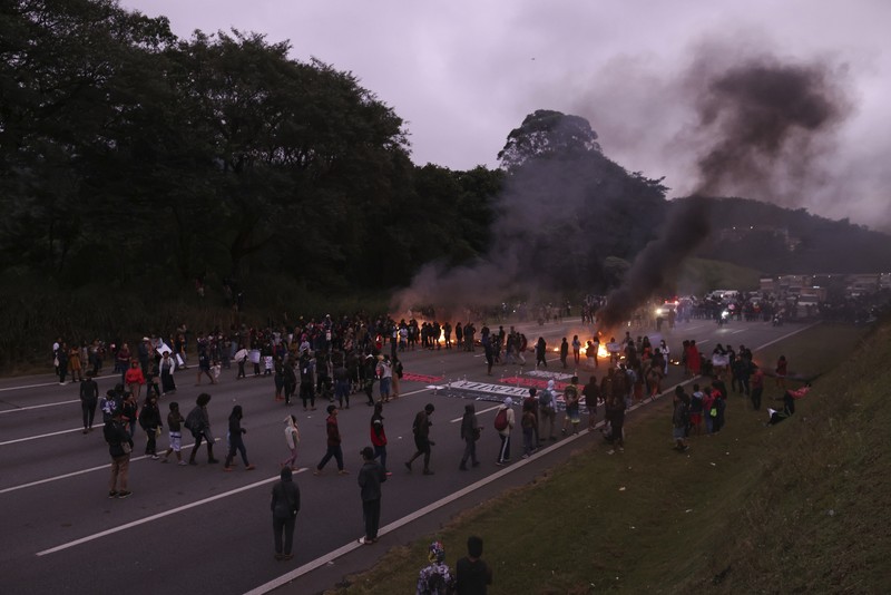 Guarani Indigenous block the Bandeirantes highway with burning tires to protest proposed legislation that would change the policy that demarcates Indigenous lands on the outskirts of Sao Paulo, Brazil, Tuesday, May 30, 2023. (AP Photo/Ettore Chiereguini)