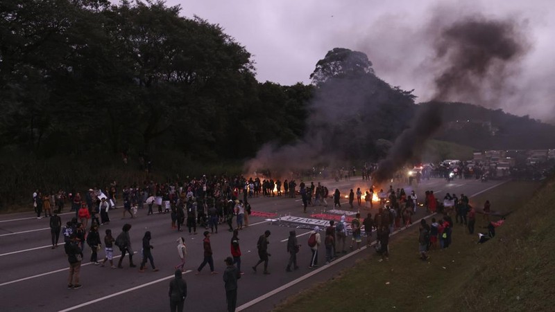 Guarani Indigenous block the Bandeirantes highway with burning tires to protest proposed legislation that would change the policy that demarcates Indigenous lands on the outskirts of Sao Paulo, Brazil, Tuesday, May 30, 2023. (AP Photo/Ettore Chiereguini)