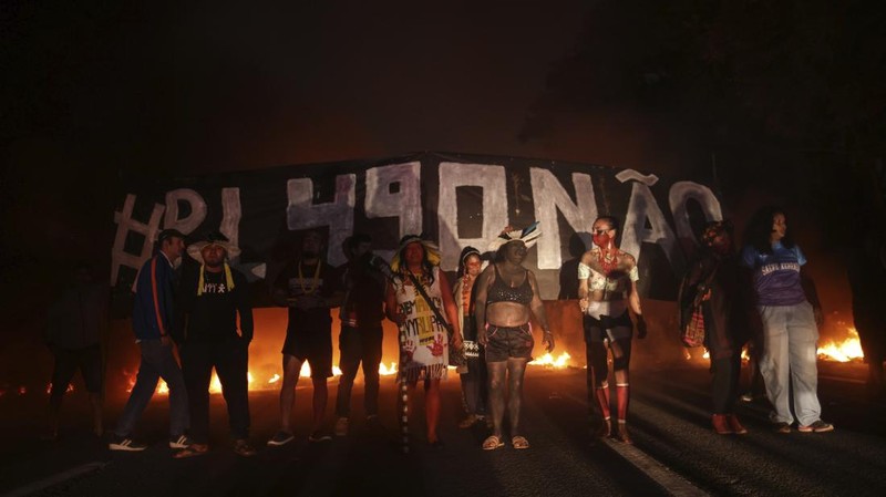 Guarani Indigenous block the Bandeirantes highway with burning tires to protest proposed legislation that would change the policy that demarcates Indigenous lands on the outskirts of Sao Paulo, Brazil, Tuesday, May 30, 2023. (AP Photo/Ettore Chiereguini)