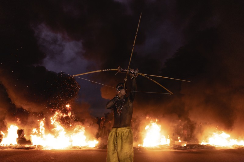 Guarani Indigenous block the Bandeirantes highway with burning tires to protest proposed legislation that would change the policy that demarcates Indigenous lands on the outskirts of Sao Paulo, Brazil, Tuesday, May 30, 2023. (AP Photo/Ettore Chiereguini)