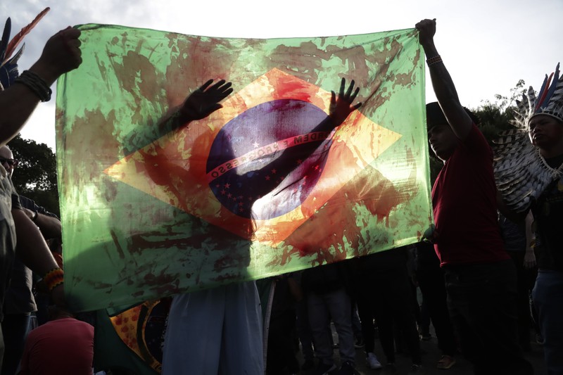 Guarani Indigenous block the Bandeirantes highway with burning tires to protest proposed legislation that would change the policy that demarcates Indigenous lands on the outskirts of Sao Paulo, Brazil, Tuesday, May 30, 2023. (AP Photo/Ettore Chiereguini)