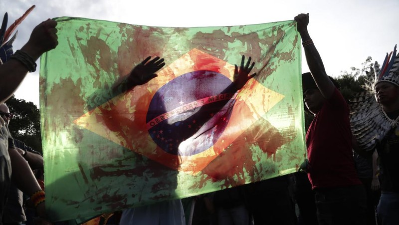 Guarani Indigenous block the Bandeirantes highway with burning tires to protest proposed legislation that would change the policy that demarcates Indigenous lands on the outskirts of Sao Paulo, Brazil, Tuesday, May 30, 2023. (AP Photo/Ettore Chiereguini)