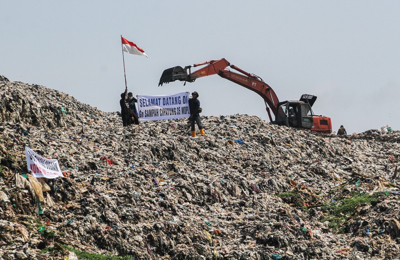Beberapa aktivis lingkungan makan di dekat tenda mereka saat aksi damai di TPA Cipayung di Depok, Provinsi Jawa Barat Indonesia pada 31 Mei 2023. Beberapa aktivis lingkungan makan di dekat tenda mereka saat aksi damai di TPA Cipayung di Depok, Provinsi Jawa Barat Indonesia pada 31 Mei 2023. Aktivis lingkungan ambil bagian dalam aksi damai untuk menunjukkan meningkatnya penumpukan sampah yang melebihi kapasitas dan menyebabkan berbagai masalah kesehatan dan lingkungan di kota. (Eko Siswono Toyudho/Anadolu Agency via Getty Images)