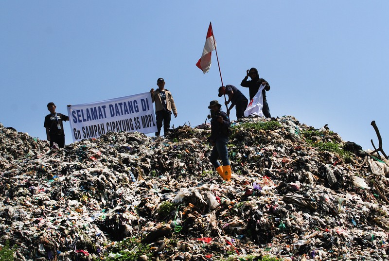 Beberapa aktivis lingkungan makan di dekat tenda mereka saat aksi damai di TPA Cipayung di Depok, Provinsi Jawa Barat Indonesia pada 31 Mei 2023. Beberapa aktivis lingkungan makan di dekat tenda mereka saat aksi damai di TPA Cipayung di Depok, Provinsi Jawa Barat Indonesia pada 31 Mei 2023. Aktivis lingkungan ambil bagian dalam aksi damai untuk menunjukkan meningkatnya penumpukan sampah yang melebihi kapasitas dan menyebabkan berbagai masalah kesehatan dan lingkungan di kota. (Eko Siswono Toyudho/Anadolu Agency via Getty Images)