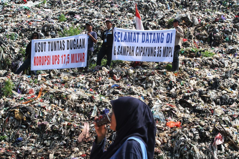 Beberapa aktivis lingkungan makan di dekat tenda mereka saat aksi damai di TPA Cipayung di Depok, Provinsi Jawa Barat Indonesia pada 31 Mei 2023. Beberapa aktivis lingkungan makan di dekat tenda mereka saat aksi damai di TPA Cipayung di Depok, Provinsi Jawa Barat Indonesia pada 31 Mei 2023. Aktivis lingkungan ambil bagian dalam aksi damai untuk menunjukkan meningkatnya penumpukan sampah yang melebihi kapasitas dan menyebabkan berbagai masalah kesehatan dan lingkungan di kota. (Eko Siswono Toyudho/Anadolu Agency via Getty Images)
