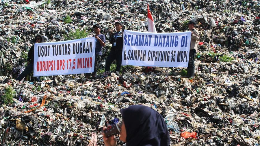 Beberapa aktivis lingkungan makan di dekat tenda mereka saat aksi damai di TPA Cipayung di Depok, Provinsi Jawa Barat Indonesia pada 31 Mei 2023. Aktivis lingkungan ambil bagian dalam aksi damai untuk menunjukkan meningkatnya penumpukan sampah yang melebihi kapasitas dan menyebabkan berbagai masalah kesehatan dan lingkungan di kota. (Eko Siswono Toyudho/Anadolu Agency via Getty Images)