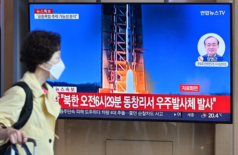 Orang-orang menonton layar televisi yang menayangkan siaran berita dengan rekaman file peluncuran roket Korea Utara, di Stasiun Kereta Api Seoul di Seoul pada 31 Mei 2023. Korea Utara meluncurkan satelit mata-mata yang diklaim pada 31 Mei, kata militer Korea Selatan, memicu kebingungan di Seoul sebagai kota secara singkat mengeluarkan peringatan evakuasi karena kesalahan. (JUNG YEON-JE/AFP via Getty Images)
