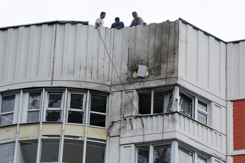UKRAINE-CRISIS/ATTACK-MOSCOW Workers repair damage on the roof of a multi-storey apartment block following a reported drone attack in Moscow, Russia, May 30, 2023. REUTERS/Maxim Shemetov TPX IMAGES OF THE DAY