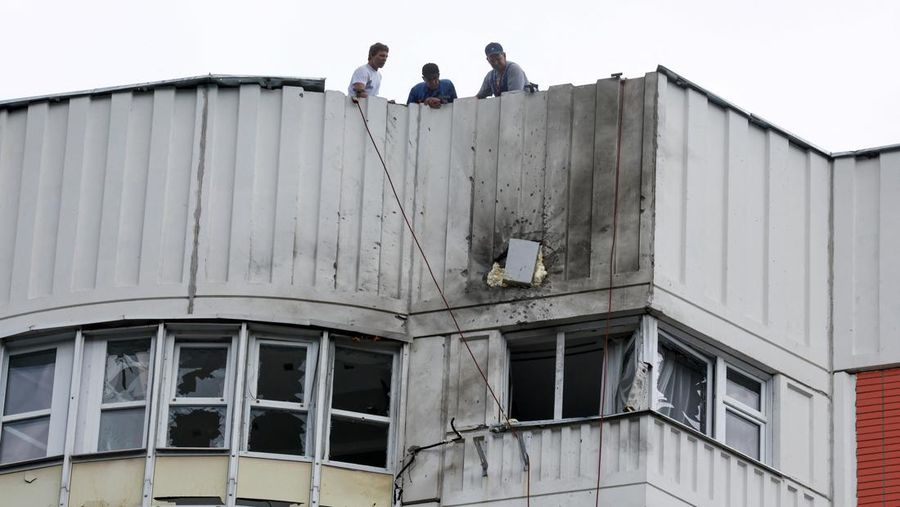 Men are seen on the roof of a damaged multi-storey apartment block following a reported drone attack in Moscow, Russia, May 30, 2023. REUTERS/Maxim Shemetov
