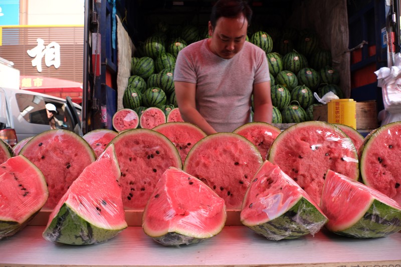 Penjualan buah semangka saat cuaca ekstre di pasar yang terletak di Shenyang, China. (Huang Jinkun/VCG via Getty Images)