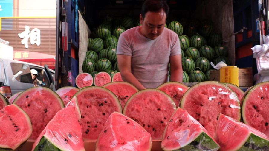 Penjualan buah semangka saat cuaca ekstre di pasar yang terletak di Shenyang, China. (Huang Jinkun/VCG via Getty Images)