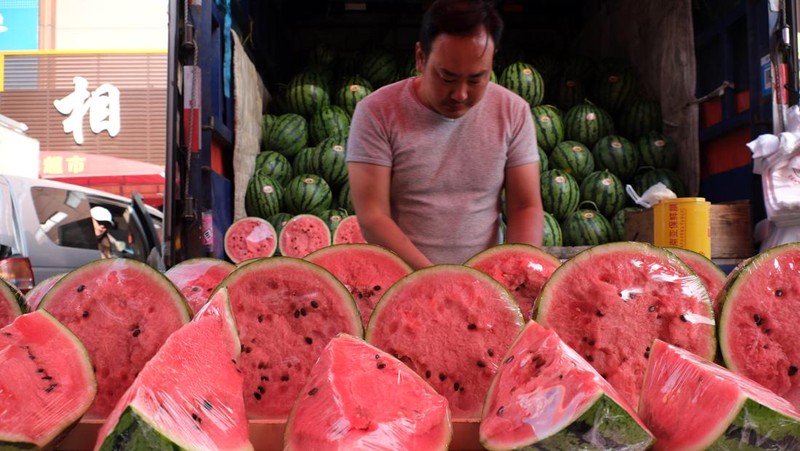 Penjualan buah semangka saat cuaca ekstre di pasar yang terletak di Shenyang, China. (Huang Jinkun/VCG via Getty Images)