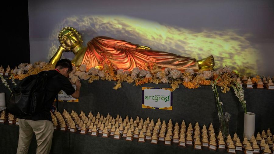Pengunjung melihat patung Buddha atau Rupang yang berukuran raksasa Tunjungan Plaza Mall, Surabaya, Jawa TImur, Kamis (1/6/2023).
(JUNI KRISWANTO/AFP via Getty Images)