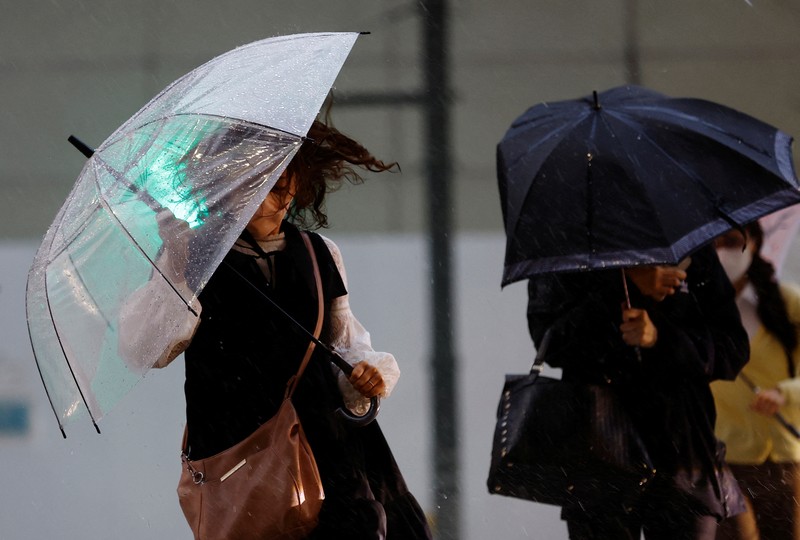 ASIA-WEATHER/JAPAN Pedestrians holding umbrellas make their way in the heavy rain in Tokyo, Japan, June 2, 2023. REUTERS/Kim Kyung-Hoon