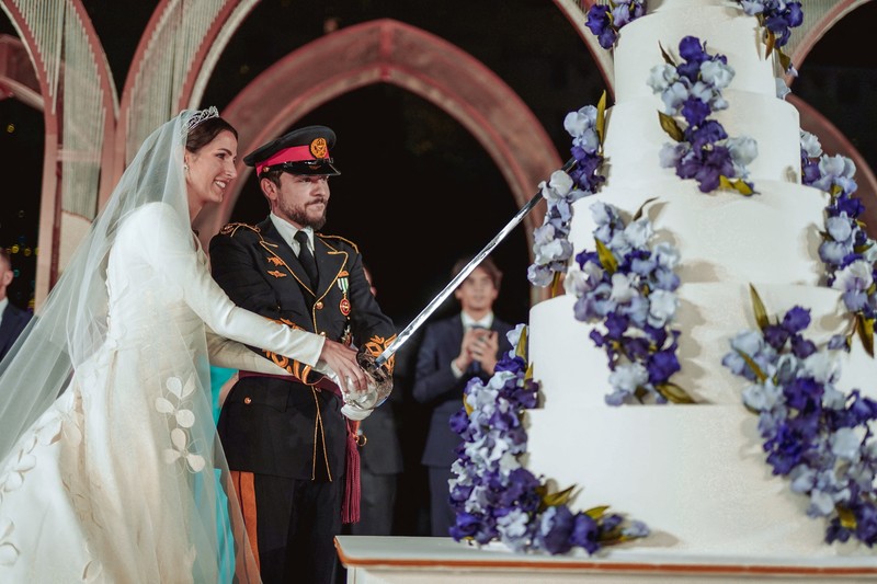 Jordan's Crown Prince Hussein and Rajwa Al Saif cut the cake on the day of their royal wedding, in Amman, Jordan, June 1, 2023. Royal Hashemite Court (RHC)/Handout via REUTERS ATTENTION EDITORS - THIS IMAGE WAS PROVIDED BY A THIRD PARTY.