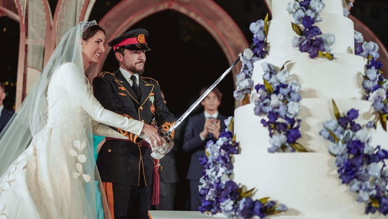 Jordan's Crown Prince Hussein and Rajwa Al Saif cut the cake on the day of their royal wedding, in Amman, Jordan, June 1, 2023. Royal Hashemite Court (RHC)/Handout via REUTERS ATTENTION EDITORS - THIS IMAGE WAS PROVIDED BY A THIRD PARTY.
