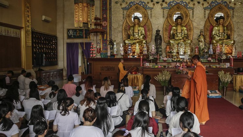 Umat ​​Buddha berdoa sebelum ritual memandikan patung Siddhartha cilik pada perayaan Hari Waisak di Vihara Buddha Dharma di Kuta, Bali, Indonesia, Minggu (4/6/2023). (Johannes P. Christo/Anadolu Agency via Getty Images)