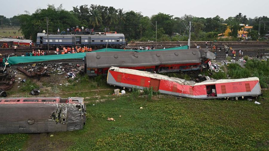 Pekerja kereta membantu memulihkan layanan di lokasi kecelakaan tabrakan tiga kereta di dekat Balasore, sekitar 200 km (125 mil) dari ibu kota negara bagian Bhubaneswar di negara bagian timur Odisha, pada 4 Juni 2023. Tim kereta api bekerja tanpa henti pada tanggal 4 Juni memulihkan jalur setelah kecelakaan kereta api paling mematikan di India dalam beberapa dekade, sebuah tragedi yang memicu kembali kekhawatiran keamanan tentang salah satu jaringan terbesar di dunia. (PUNIT PARANJPE/AFP via Getty Images)