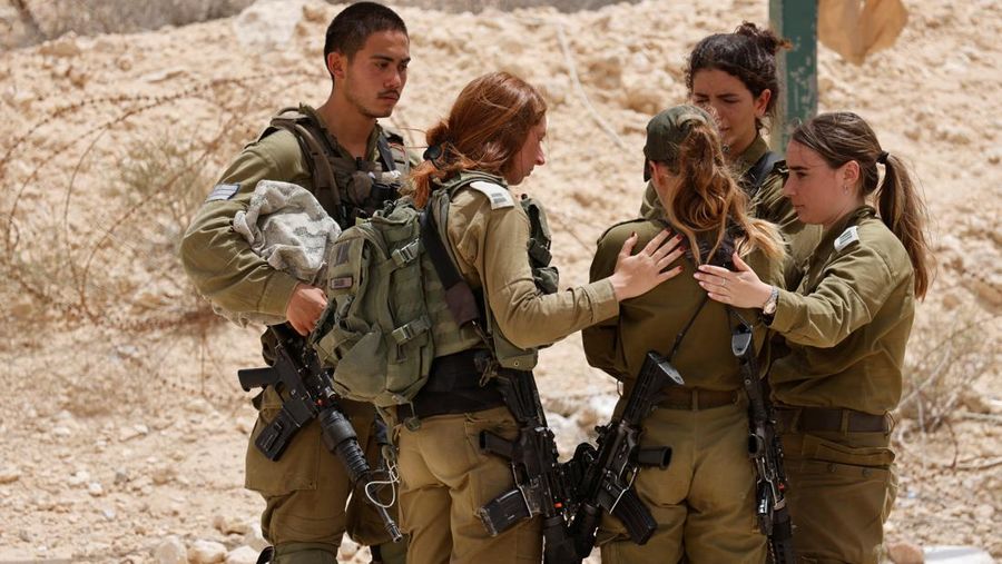 Tentara Israel saling menghibur di luar pangkalan militer Gunung Harif dekat kota Mitzpe Ramon di gurun Negev selatan Israel, berdekatan dengan perbatasan dengan Mesir, pada 3 Juni 2023. Dua tentara Israel tewas dalam penembakan yang jarang terjadi di perbatasan Mesir, memicu perburuan di mana tentara ketiga dan 
