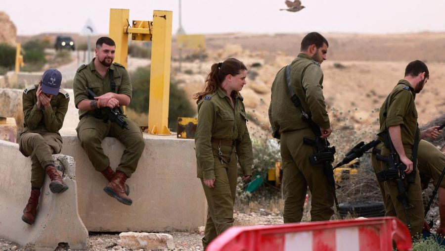 Tentara Israel saling menghibur di luar pangkalan militer Gunung Harif dekat kota Mitzpe Ramon di gurun Negev selatan Israel, berdekatan dengan perbatasan dengan Mesir, pada 3 Juni 2023. Dua tentara Israel tewas dalam penembakan yang jarang terjadi di perbatasan Mesir, memicu perburuan di mana tentara ketiga dan 