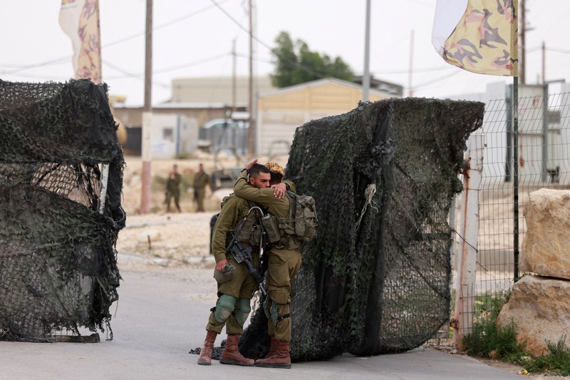 Tentara Israel saling menghibur di luar pangkalan militer Gunung Harif dekat kota Mitzpe Ramon di gurun Negev selatan Israel, berdekatan dengan perbatasan dengan Mesir, pada 3 Juni 2023. Tentara Israel saling menghibur di luar pangkalan militer Gunung Harif dekat kota Mitzpe Ramon di gurun Negev selatan Israel, berdekatan dengan perbatasan dengan Mesir, pada 3 Juni 2023. Dua tentara Israel tewas dalam penembakan yang jarang terjadi di perbatasan Mesir, memicu perburuan di mana tentara ketiga dan