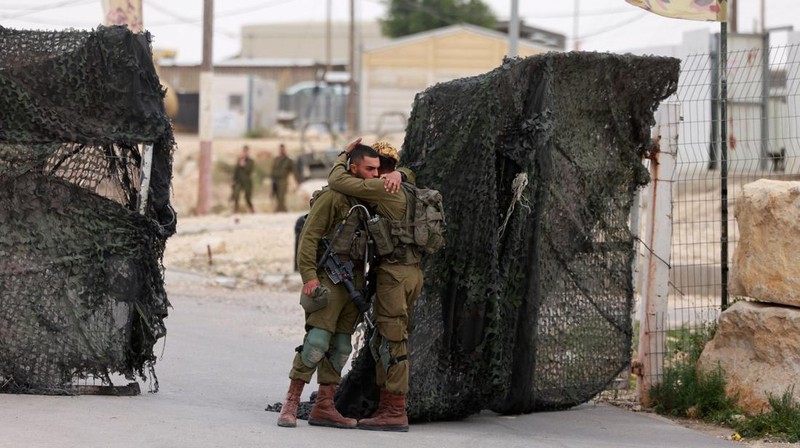 Tentara Israel saling menghibur di luar pangkalan militer Gunung Harif dekat kota Mitzpe Ramon di gurun Negev selatan Israel, berdekatan dengan perbatasan dengan Mesir, pada 3 Juni 2023. Dua tentara Israel tewas dalam penembakan yang jarang terjadi di perbatasan Mesir, memicu perburuan di mana tentara ketiga dan 