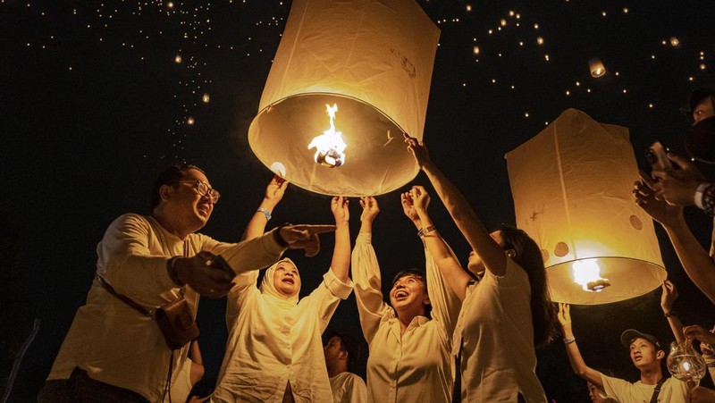 Umat Buddha dan turis melepaskan lampion ke udara di Candi Borobudur saat perayaan Hari Raya Waisak pada 4 Juni 2023 di Magelang, Jawa Tengah, Indonesia. Waisak dirayakan selama bulan purnama di bulan Mei atau Juni dengan upacara yang berpusat di sekitar tiga candi Budha, peziarah berjalan dari Mendut ke Pawon, berakhir di Borobudur. Hari suci merayakan kelahiran, pencerahan ke nirwana, dan meninggalnya Buddha Gautama, pendiri agama Buddha. (Ulet Ifansasti/Getty Images)