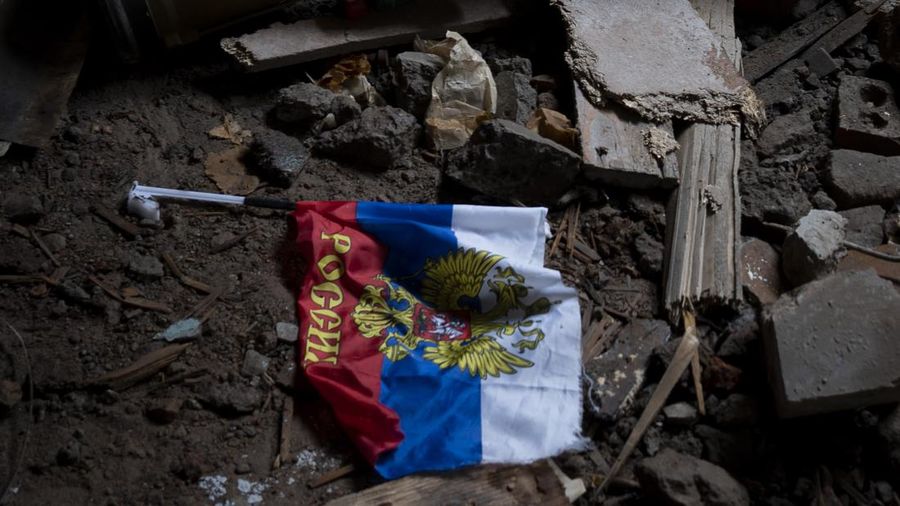 Bendera Rusia yang lusuh jatuh di tanah sebuah gedung yang hancur. (File Foto - Ashley Chan/SOPA Images/LightRocket via Getty Images)