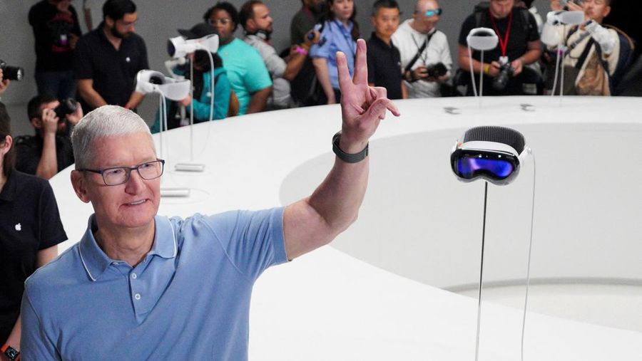 CEO Apple Tim Cook berpose di samping headset Vision Pro Apple pada Konferensi Pengembang Sedunia tahunan Apple di kantor pusat perusahaan di Cupertino, California, AS 5 Juni 2023. (REUTERS/Loren Elliott)