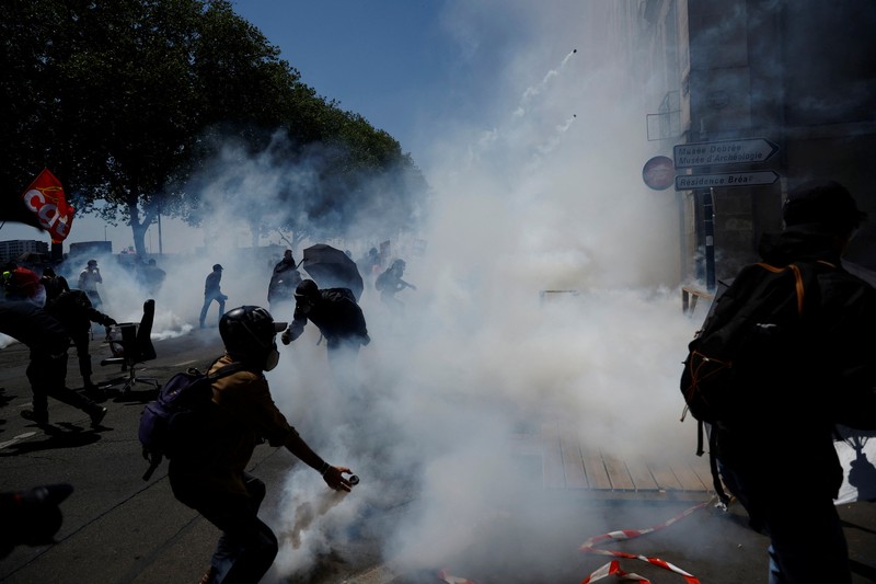 A masked prostester holds a red flare during clashes at a demonstration as part of the 14th day of nationwide protests against French government's pension reform law, in Nantes, France, June 6, 2023.  REUTERS/Stephane Mahe