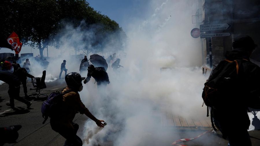A masked prostester holds a red flare during clashes at a demonstration as part of the 14th day of nationwide protests against French government's pension reform law, in Nantes, France, June 6, 2023.  REUTERS/Stephane Mahe